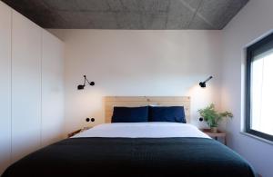 里斯本Columbano Suites Hotel Lisboa - Praça de Espanha, Sete Rios - Bookable parking的一间卧室配有一张带蓝色枕头的大床