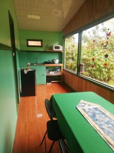 圣赫拉多德多塔Cabañas San Gerardo的厨房配有绿桌和2扇窗户。