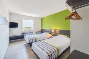 比亚埃尔莫萨City Express Junior by Marriott Villahermosa的绿墙客房的两张床
