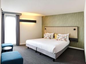 瓦夫尔瓦夫尔贝斯特韦斯特酒店的一间卧室配有一张大床和一张蓝色椅子