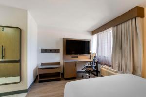 弗拉格斯塔夫Aiden by Best Western Flagstaff的酒店客房配有一张床和一张书桌及一台电视