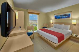 坎佩切坎佩切都市快捷酒店的一间卧室配有一张床和一台平面电视