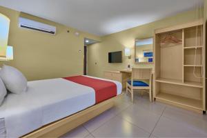 坎佩切坎佩切都市快捷酒店的配有一张床和一张书桌的酒店客房