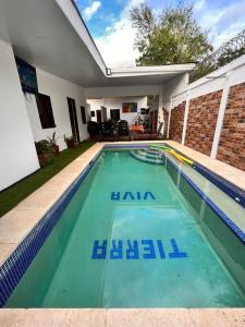 马那瓜Casa Tierra Viva的一座房子前面的蓝色海水游泳池