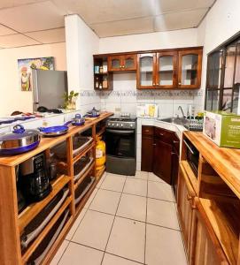 马那瓜Casa Tierra Viva的厨房配有木制橱柜和炉灶烤箱。