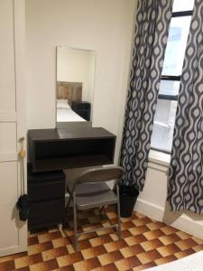 纽约1C CLOSe的钢琴,带镜子和椅子的房间