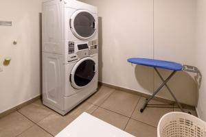 波哥大City Express Junior by Marriott Bogota Aeropuerto的蓝色凳子的房间的洗衣机和烘干机