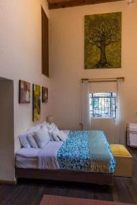 墨西哥城Meztli: Casa Boutique & Spa的卧室配有一张挂在墙上的树画床。