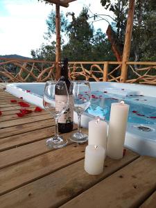 圣埃伦娜Guayacan Alojamiento的热水浴池旁的桌子配有酒杯和蜡烛