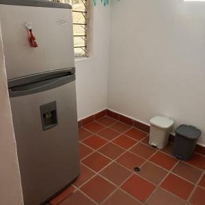 圣埃伦娜Guayacan Alojamiento的带冰箱的厨房和红色瓷砖地板。