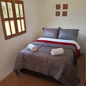 圣埃伦娜Guayacan Alojamiento的一间卧室配有一张床,上面有两条毛巾