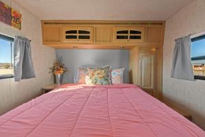 约书亚树JT Village Campground - Star Stream的窗户客房内的一张粉红色大床