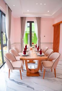 巴地市Trân Châu Beach & Resort的一间带木桌和椅子的用餐室
