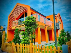 巴地市Trân Châu Beach & Resort的一座橙色房子,前面有栅栏
