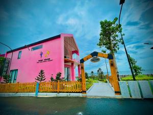 巴地市Trân Châu Beach & Resort的粉红色的建筑,前面有栅栏