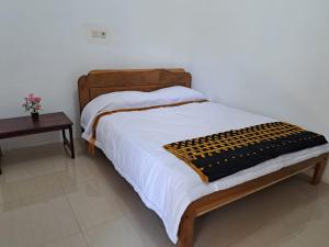 RiungRiung Tiga Empat Tujuh Guesthouse的一张带木制床头板和桌子的床