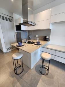巴兰基亚Apartaestudio DISTRITO 90的厨房配有2把吧台凳和台面
