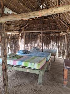 WarsobtuguaCabañas tradicionales en isla Aroma的稻草小屋内带两张床的房间