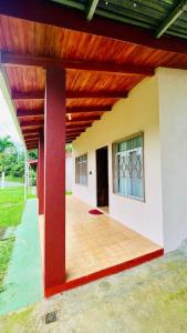 纽沃阿雷纳尔Beautiful Casa Aire near Lake Arenal in Nuevo Arenal - Casas Airelibre的木屋顶房子的门廊