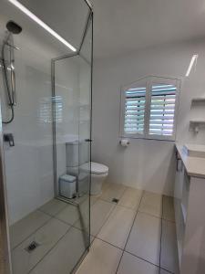 拜伦湾拜伦湾海滨公寓的一间带玻璃淋浴和卫生间的浴室