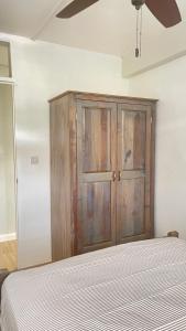 罗索Travellers Villa的一间卧室配有一张床和一个木制橱柜