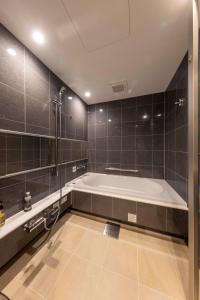 敦贺市Hotel Granbinario Tsuruga的大型浴室设有浴缸和淋浴。