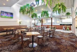 悉尼Penshurst Hotel的用餐室配有桌椅和植物