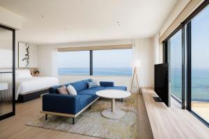 淡路Fairfield by Marriott Hyogo Awaji Higashiura的客厅配有蓝色的沙发和床。
