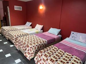 巴力拉惹Ayem Homestay UTHM的红色墙壁的房间里设有三张床