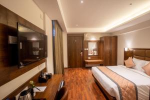 班加罗尔Golden Fortune Hotel的配有一张床和一张书桌的酒店客房