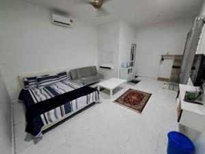 麻坡Esah Best INN的白色卧室配有床和沙发