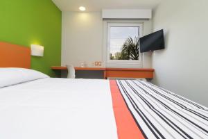 托卢卡City Express Junior by Marriott Toluca Aeropuerto的一间卧室配有一张床、一张书桌和一个窗户。