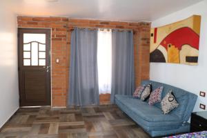 乔卢拉Alojamiento HM的客厅设有蓝色的沙发和砖墙