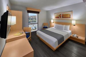 诺加利斯诺加利斯城市快捷酒店的酒店客房,配有床和电视