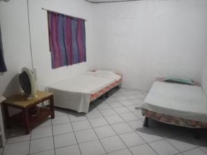 维拉港Bluepango Guest House的客房设有两张床、一台电视和一张桌子。