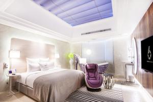 桃园市六星-桃园馆的一间卧室配有一张大床和紫色椅子