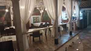 博卡奇卡米拉朵儿公寓的一间设有白色窗帘和桌椅的用餐室