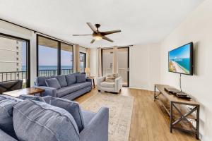 罗马尔海滩Seaside Beach & Racquet 5614的客厅配有蓝色的沙发和吊扇
