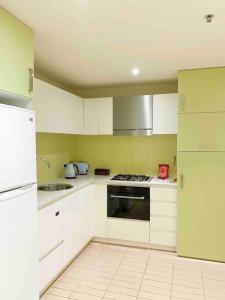 格莱内尔格SUNSET GETAWAY GLENELG的厨房配有白色橱柜和炉灶烤箱。