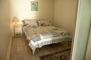 格莱内尔格SUNSET GETAWAY GLENELG的一间卧室配有一张床和一个带灯的床头柜