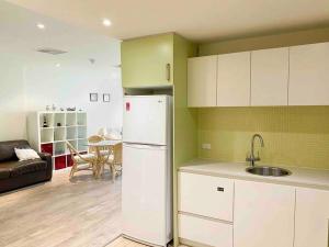 格莱内尔格SUNSET GETAWAY GLENELG的一间带白色冰箱的厨房和一间客厅