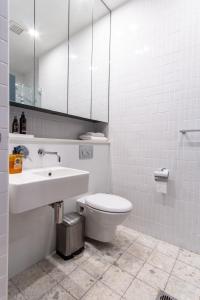 悉尼Eggies Nest - Sydney City Apartment的一间带水槽、卫生间和镜子的浴室