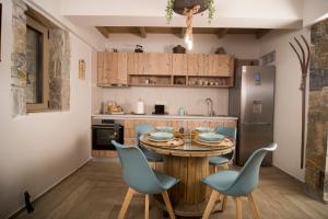 AlmirónWood&Stone Guesthouse的厨房配有木桌和蓝色椅子