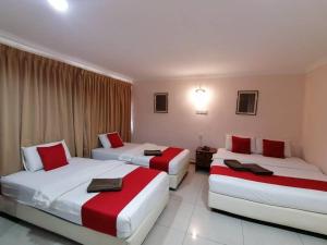 拉布安HOTEL PANTAI VIEW的红色和白色的酒店客房内的两张床
