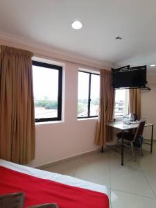 拉布安HOTEL PANTAI VIEW的客房设有书桌、电视和2扇窗户。