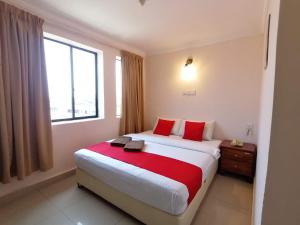 拉布安HOTEL PANTAI VIEW的一间卧室配有一张带红色枕头的大床和窗户