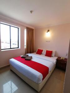 拉布安HOTEL PANTAI VIEW的酒店客房配有一张带红色枕头的大床