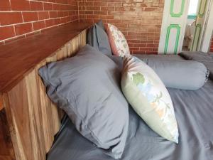 外南梦Pondok isoke bunggalow的一张带两个枕头和砖墙的床