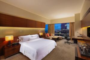 广州广州海航威斯汀酒店的一间带白色大床的卧室和一间客厅