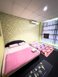 斗湖VIE HOMESTAY TAWAU的配有粉红色床单的客房内的两张床